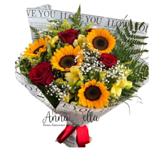 Gran ramo floral compuesto por cuatro girasoles amarillos, cuatro rosas premium y varas de astromelias con follaje verde, envuelto en papel decorativo elegante con lazo de satén.