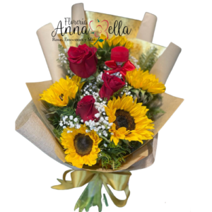 Ramo floral compuesto por cinco grandes girasoles amarillos y tres rosas premium de corte fresco, acompañados de follaje verde y envueltos en papel decorativo elegante con un lazo artesanal.