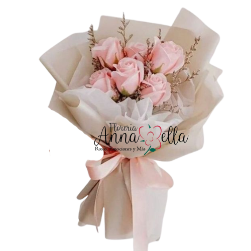 Seis rosas de color rosa suave con pétalos grandes y firmes, dispuestas de forma escalonada con follaje fino, envueltas en papel de seda y papel artesanal color crema con un lazo de raso.