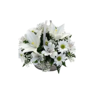 Fotografía de un canasto de mimbre delicado que contiene un arreglo floral de cinco liliums blancos grandes y cinco margaritas de pétalos blancos con centro amarillo, rodeados de follaje verde fino y silvestre sobre un fondo luminoso neutro